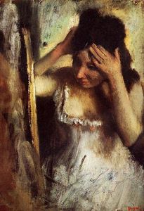 Mujer que se peina el pelo ante  Un  espejo