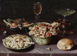 a still life of porcelain vessels containing sweets, pewter plates bearing sweets and chestnuts, three pieces of glassware and a bread roll on a table draped with a mauve cloth