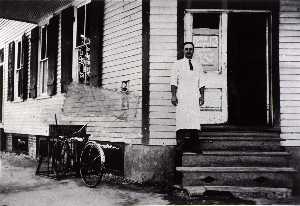 Henry Macrini in doorway of store, H M Grocery at 1627 Avenue H, 1928, from The Corner Stores of Galveston, Galveston County Cultural Arts Council