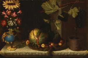 Still life of a sunflower and other blooms in a gilt mounted bluestone vase, together with melons, apricots, grapes and plums in a pewter dish alongside a planter with grapes on a vine branch, all on a carved marble ledge